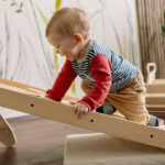 Kleinkund krabbelt flache Leiter hoch