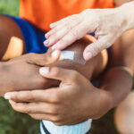 Kind bekommt beim Fußballspielen Pflaster auf sein Knie