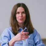 Frau in blauer Hemdbluse redet und artikuliert